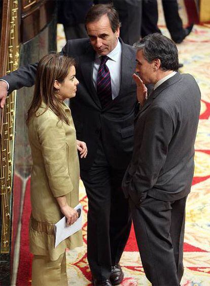 La portavoz del PP, Soraya Sáenz de Santamaría, conversa con los socialistas José Antonio Alonso y Ramón Jáuregui ayer en el Congreso.