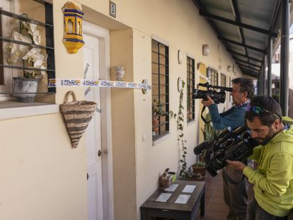 Los equipos de televisión graban la entrada de la casa donde se encontró el cadáver de la mujer, precintada por la Policía Nacional.