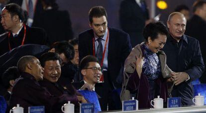 El presidente ruso, Vladímir Putin, ayuda a ponerse una manta sobre los hombros a Peng Liyuan, mujer de su homólogo chino Xi Jinping, sentado junto a Barack Obama. Pekín ha tratado de censurar el vídeo con la escena.