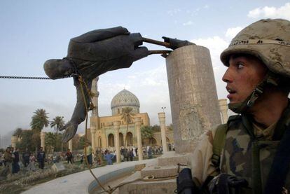 9 de abril de 2003. Soldados estadounidenses y civiles iraquíes derriban una estatua de Sadam Husein, tras entrar en la ciudad de Bagdad.