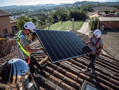 Unos operarios instalan unas placas solares en una casa de Barcelona.