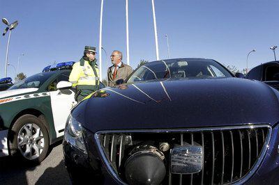 El director general de Tráfico, Pere Navarro, habla con un guardia civil, junto a un vehículo camuflado con radar.