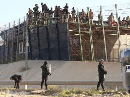 Un grupo de inmigrantes subidos al techo del puesto fronterizo, el jueves.