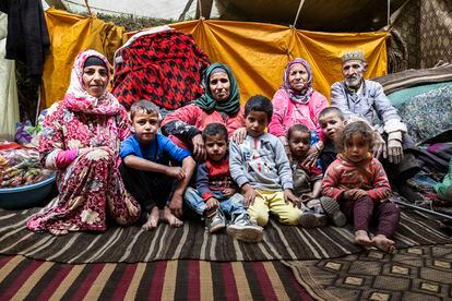 De izquierda a derecha, Fatma Ait-Buri, Zahara Ait-Mjud, Aicha Ait-Buasis y Mohamed Ait-Mjud, de 70 años, padres de Aicha, junto a seis niños de su familia, en la tienda improvisada que se ha convertido en su hogar.