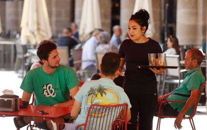Una trabajadora de hostelería atiende a unos clientes en Bilbao.