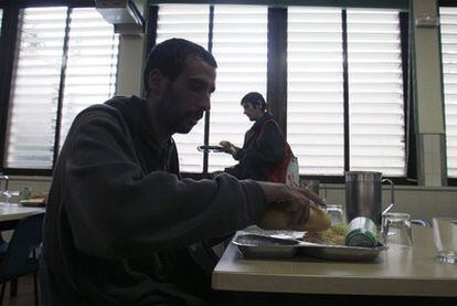 Un hombre come en un comedor social en Madrid.