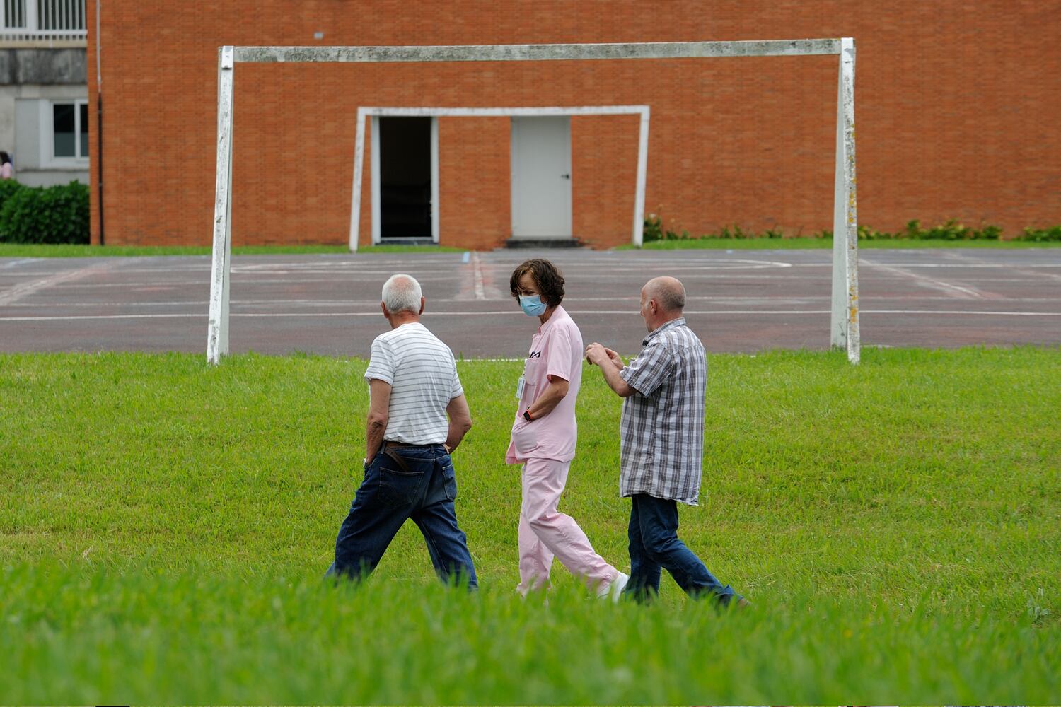 Pacientes del Hospital Psiquiátrico de Zamudio, pasean por el jardín en compañía de una auxiliar de enfermería.