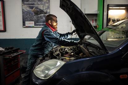 A mechanic works in an automotive workshop.