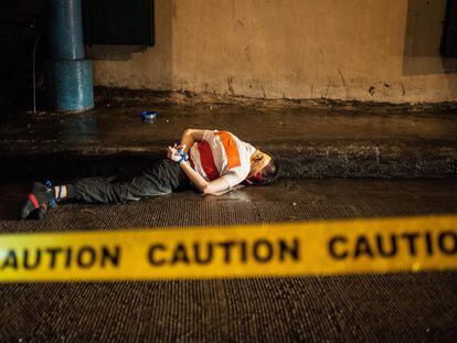 Una víctima de una ejecución sumaria yace muerto en la calle con la boca tapada con cinta de embalaje en Manila (Filipinas).
