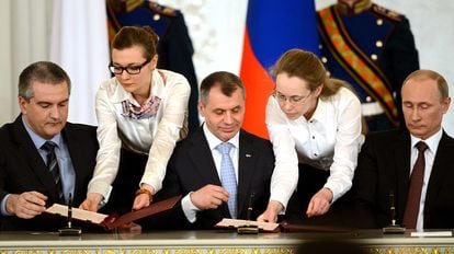 Russian President Vladimir Putin, on the right of the image, signs the annexation of Crimea with representatives of the peninsula, on March 18, 2014 in Moscow. 