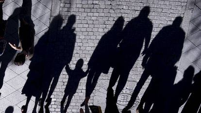 La sombra de un menor y varios adultos en una calle de Sevilla.
