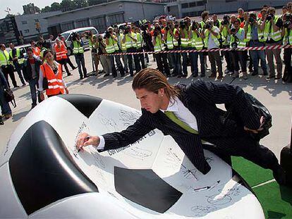Sergio Ramos firma en un balón de Kamen a su llegada a la concentración de España en Alemania.