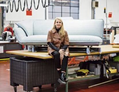 Patricia Urquiola posa en el centro de producción de Cassina ante su sofá Beam, caracterizado por la viga metálica en que se sostiene.