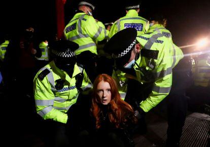 Agentes de Scotland Yard detienen a una mujer la noche del sábado en la vigilia de Clapham, en Londres. 