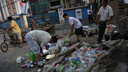 Ciudadanos chinos recogen basura en una calle de Pekín.