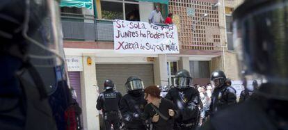 Los mossos d'esquadra detienen a una de las personas que intentaban evitar el desahucio de un piso en Barcelona en julio.
