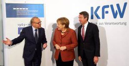 La canciller alemana, Angela Merkel (c) junto al director del Consejo Alemán de Expertos Económicos, Wolfgang Franz (i) y el presidente del grupo bancario KfW, Ulrich Schroeder (d). EFE/Archivo
