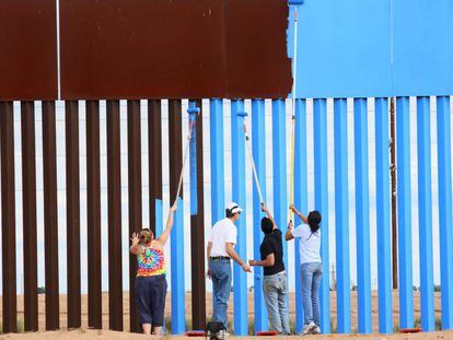 Voluntarios de Erasing the Border pintan la barrera entre EE&nbsp;UU y M&eacute;xico para hacerla invisible.