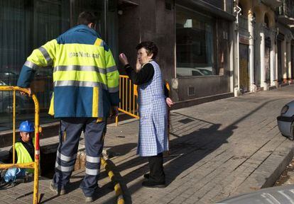 Una vecina del Poblenou, Rosal&iacute;a, inquiere a un operario sobre la marcha de los trabajos de reparaci&oacute;n.