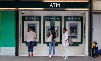 Dos mujeres utilizan los cajeros automáticos del banco Nedbank en Ciudad del Cabo, Sudáfrica, el 15 de marzo de 2016.