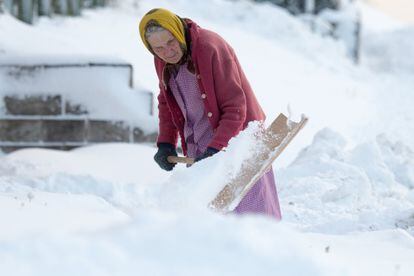 Una mujer mayor retira nieve acumulada del pavimento en la entrada de su casa en Saulburg, al sur de Alemania.