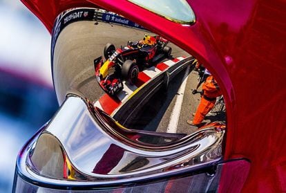 El piloto holandés Max Verstappen de la escudería Red Bull se ve reflejado en el casco de un bombero mientras participa en una sesión de entrenamiento en el circuito de Montecarlo, en Mónaco.