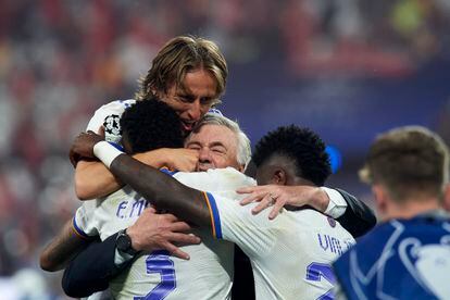 Luka Modric, Vinicius Junior, Eder Militao y Carlo Ancelotti se abrazan en el césped del Stade de France de París.