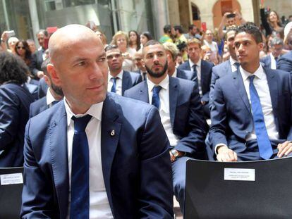 Zidane, en la sede de la Comunidad de Madrid. Detr&aacute;s, Benzema y Varane.