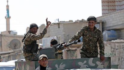 Milicianos kurdos celebran su entrada en un pueblo de Tel Abyad.