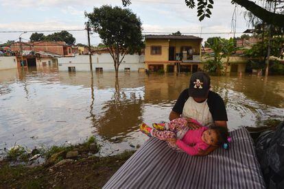 Un hombre juega con su hija en mitad de la inundación en Cali, Colombia.