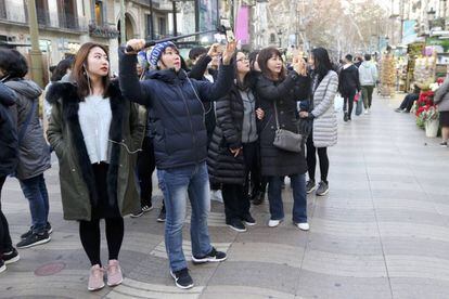 Turistas visitan las Ramblas de Barcelona.
