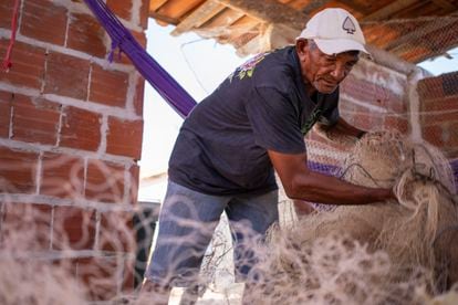 El pescador jubilado Antônio Ferreira de Oliveira, de 70 años, organiza las redes de pesca en su casa. 