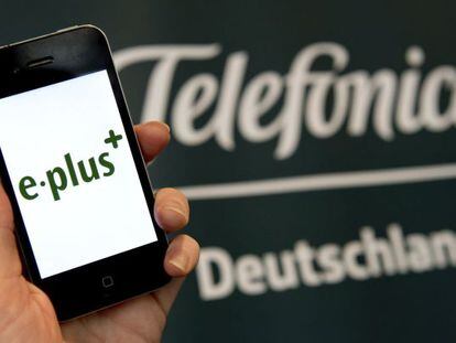 Un m&oacute;vil de E-Plus junto al logo de Telef&oacute;nica Deutschland.