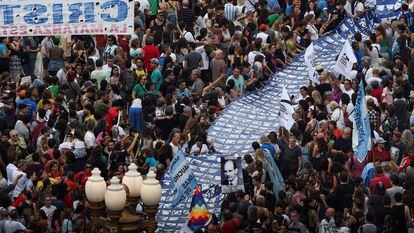 Miles de personas marchan hacia Plaza de Mayo con una gran pancarta con rostros de desaparecidos durante la última dictadura argentina.