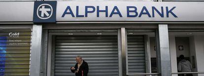 Ciudadanos, delante de una sucursal de Alpha Bank en Atenas.