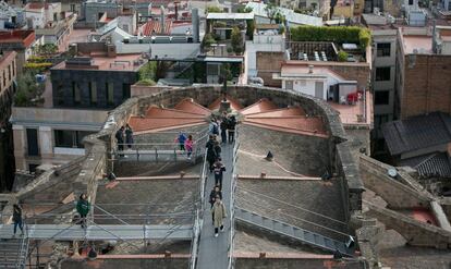 Visitants a la catedral de Barcelona passejant pel teulat del temple.