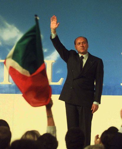 El ex primer ministro italiano y magnate de los medios de comunicación, Silvio Berlusconi saluda a los seguidores después de haber sido elegido de nuevo como presidente del partido Forza Italia, durante un mítin en Milan, el 18 de abril de 1998.