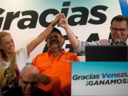 La esposa del Leopoldo López, Lilian Tintori, levanta la mano junto a Enrique Marquez.