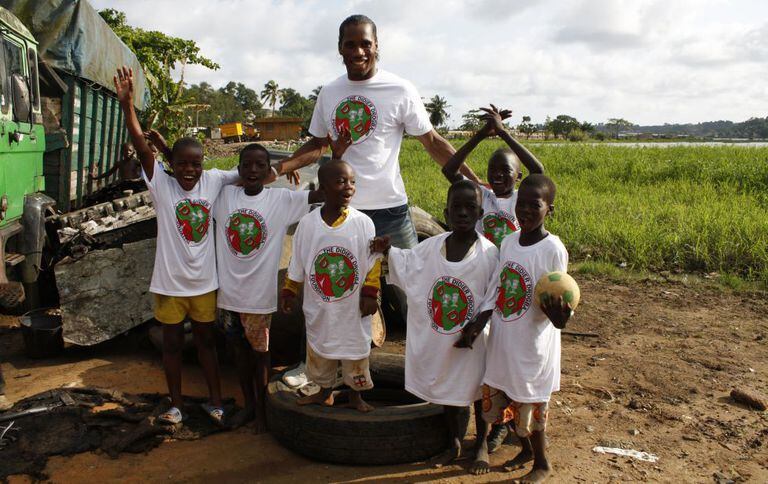 Didier Drogba posa con unos niños de su fundación, en Costa de Marfil.