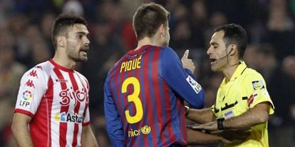 Piqué protesta al árbitro Velasco Carballo tras ser expulsado durante el partido ante el Sporting de Gijón