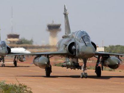 Un soldado dirige a dos aviones caza franceses Mirage tras su aterrizaje el jueves en el aeropuerto de Bamako, capital de Mal&iacute;.