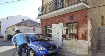 Un vecino observa la vivienda precintada de la calle Tarragona de Armilla (Granada) tras el asesinato de un hombre.