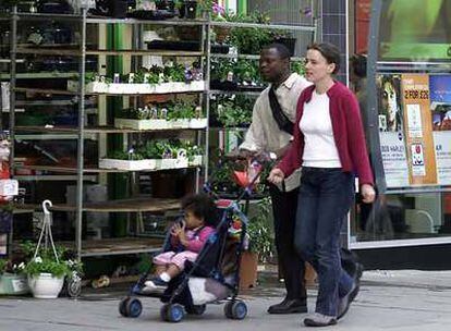 Una pareja  pasea con su hijo por una calle de Londres.