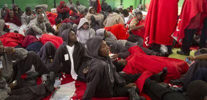 Inmigrantes descansan dentro de un centro deportivo en Tarifa, este martes.