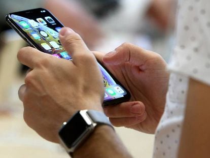 Un usuario sostiene un iphone en la tienda de Apple de la Puerta del Sol de Madrid.