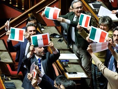 Miembros de la oposición italiana ondean banderas tricolores en protesta por la aprobación en el Senado de la nueva ley de autonomías, este lunes en Roma.