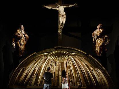 Dos personas contemplan la venera de la cúpula del retablo mayor de San Benito el Real, obra de Alonso Berruguete, este martes en Valladolid.