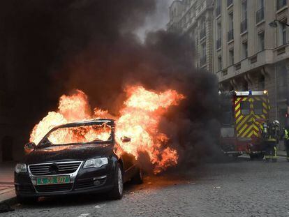 Un coche arde en París cerca del Arco del Triunfo.