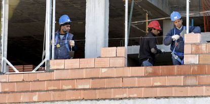 Tres obreros trabajan en la construcci&oacute;n de una vivienda. EFE/Archivo