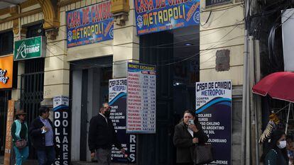 Ciudadanos pasan frente a un par de locales de venta de divisas en La Paz, en marzo pasado.
